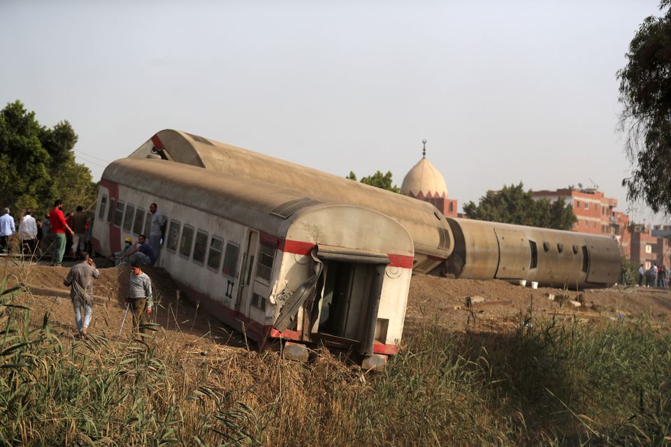 People gather at the site where train carriages derailed in Qalioubia province, north of Cairo, Egypt April 18, 2021. Photo: Reuters