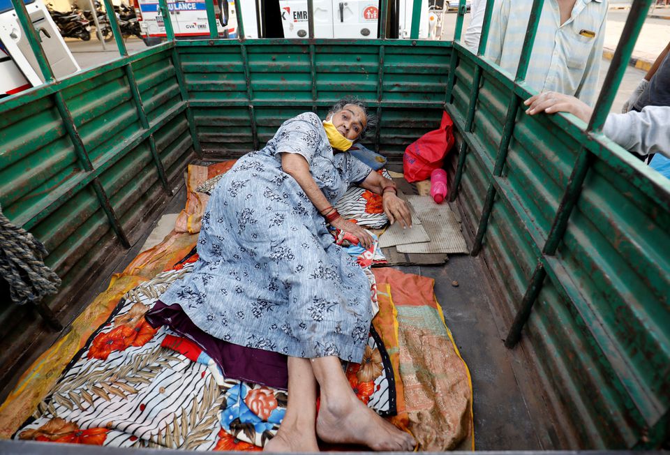 A woman lies in the back of a load carrier waiting to enter a COVID-19 hospital for treatment, amidst the spread of the coronavirus disease (COVID-19), in Ahmedabad, India, April 26, 2021. Photo: Reuters