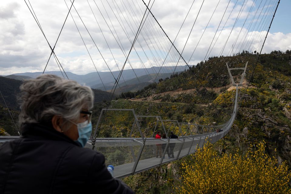 People walk on the world's longest pedestrian suspension bridge '516 Arouca', now open for local residents in Arouca, Portugal, April 29, 2021. Photo: Reuters