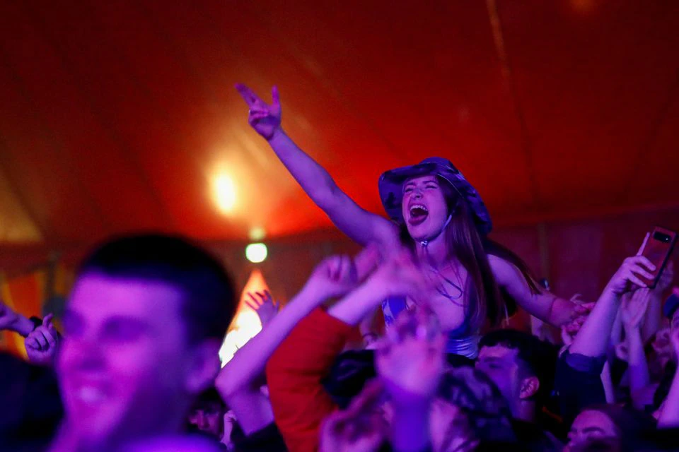 A woman enjoys her time during a test music festival as part of a national research program assessing the risk of COVID-19 transmission in Liverpool, Britain May 2, 2021. Photo: Reuters