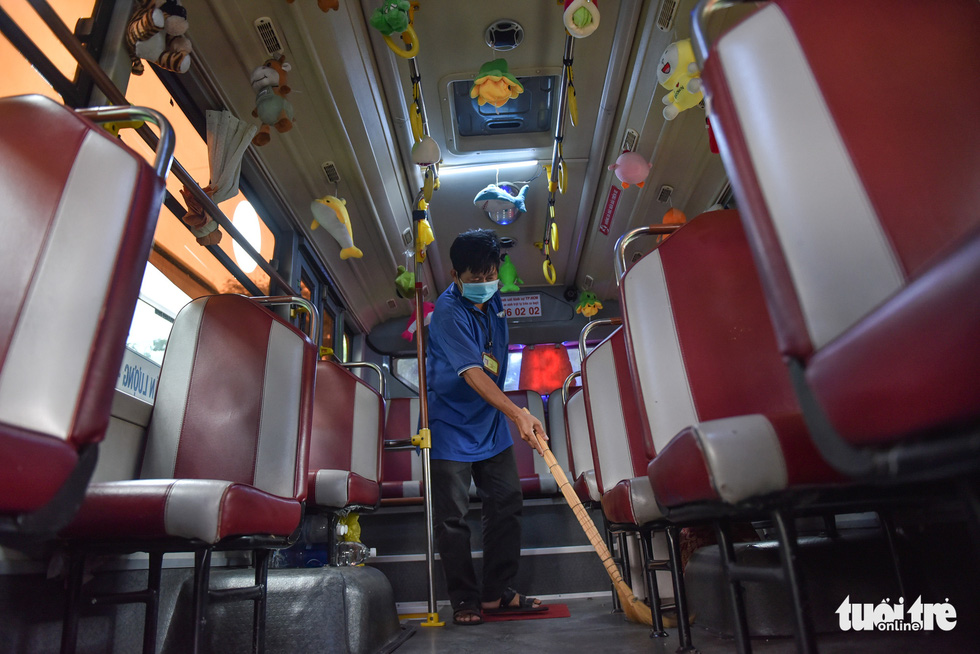 Pham Van Sang, an attendant on bus route No.146 in Ho Chi Minh City, cleans up a vehicle that he works on. Photo: Ngoc Phuong / Tuoi Tre