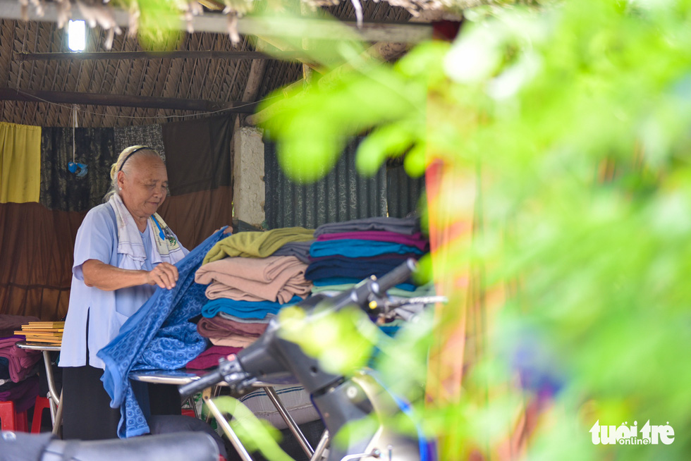 She folds blankets waiting to be distributed. – Photo: Ngoc Phuong/Tuoi Tre