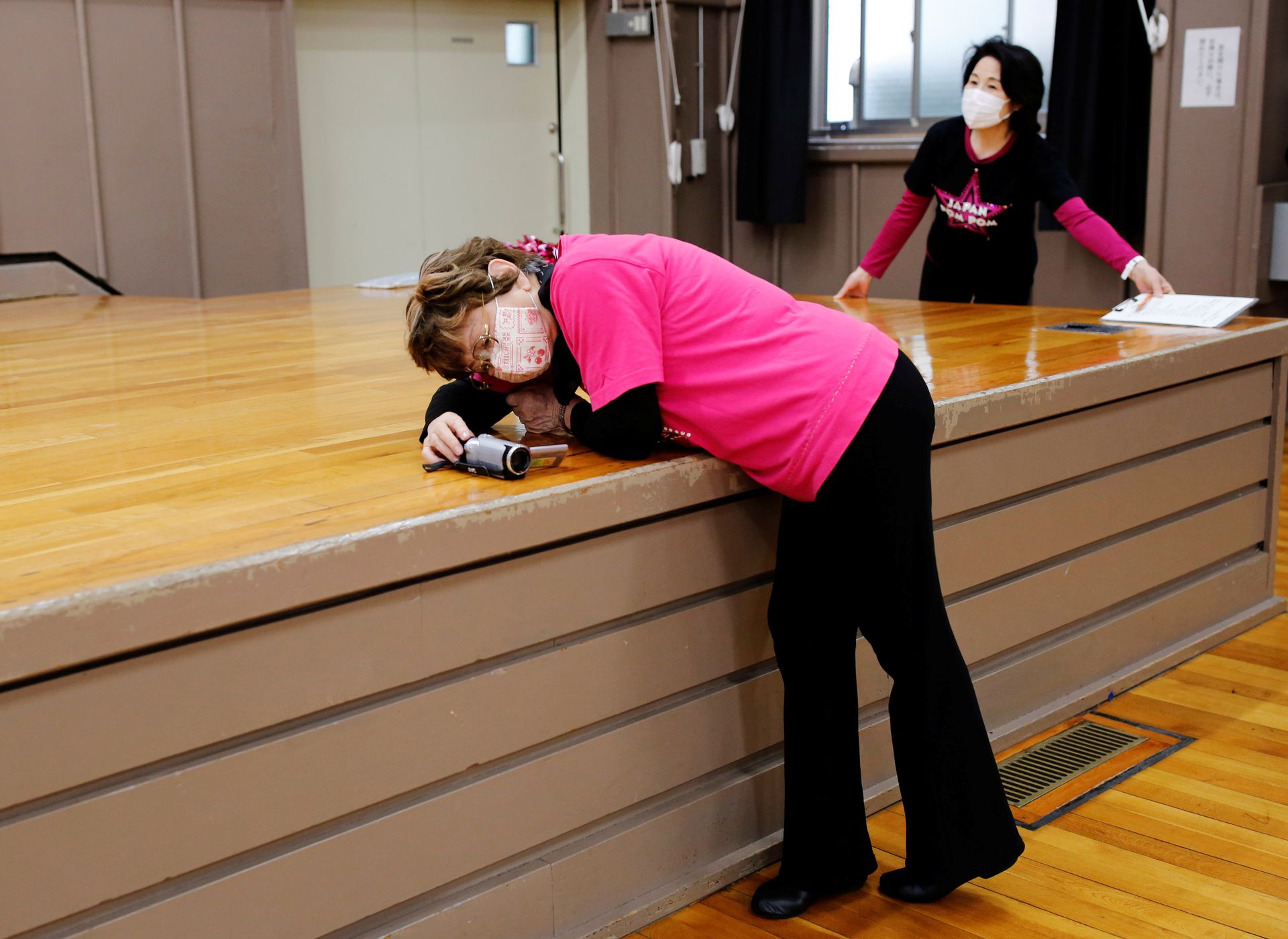 Fumie Takino, 89, founder of a senior cheer squad called Japan Pom Pom, sets up a video camera to film the team's dance routine during a weekly practice session in Tokyo, Japan April 5, 2021. Photo: Reuters