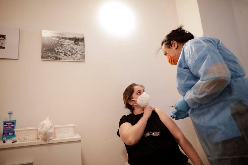 A woman reacts after being vaccinated against coronavirus disease (COVID-19) in the temporary vaccination center at Bran castle, in Brasov county, Romania, May 8, 2021. Inquam Photos/George Calin via Reuters