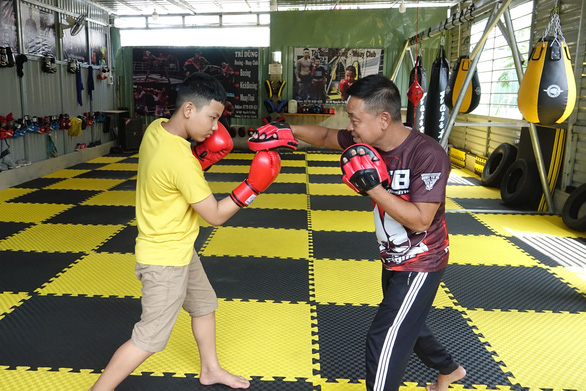 Nguyen Tri Dung and his father, Nguyen Phu Cuong, practice boxing in their private martial arts center. Photo: Hoang Tung / Tuoi Tre
