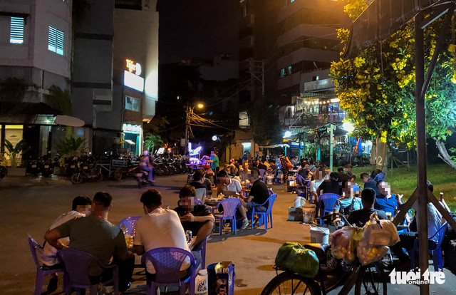 The pub at the end of Truong Sa Street in Ward 19, Binh Thanh District, Ho Chi Minh City is overcrowded with drinkers, many of whom are arranged to sit on the roadway. Photo: Chau Tuan / Tuoi Tre
