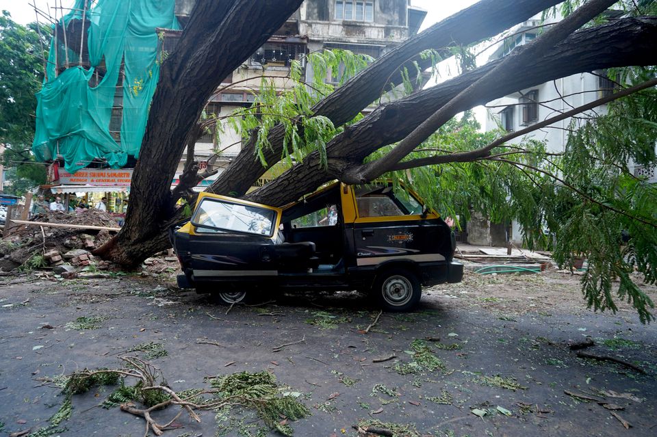 A damaged vehicle is seen under a fallen tree on a road after heavy winds caused by Cyclone Tauktae, in Mumbai, India, May 18, 2021. Photo: Reuters