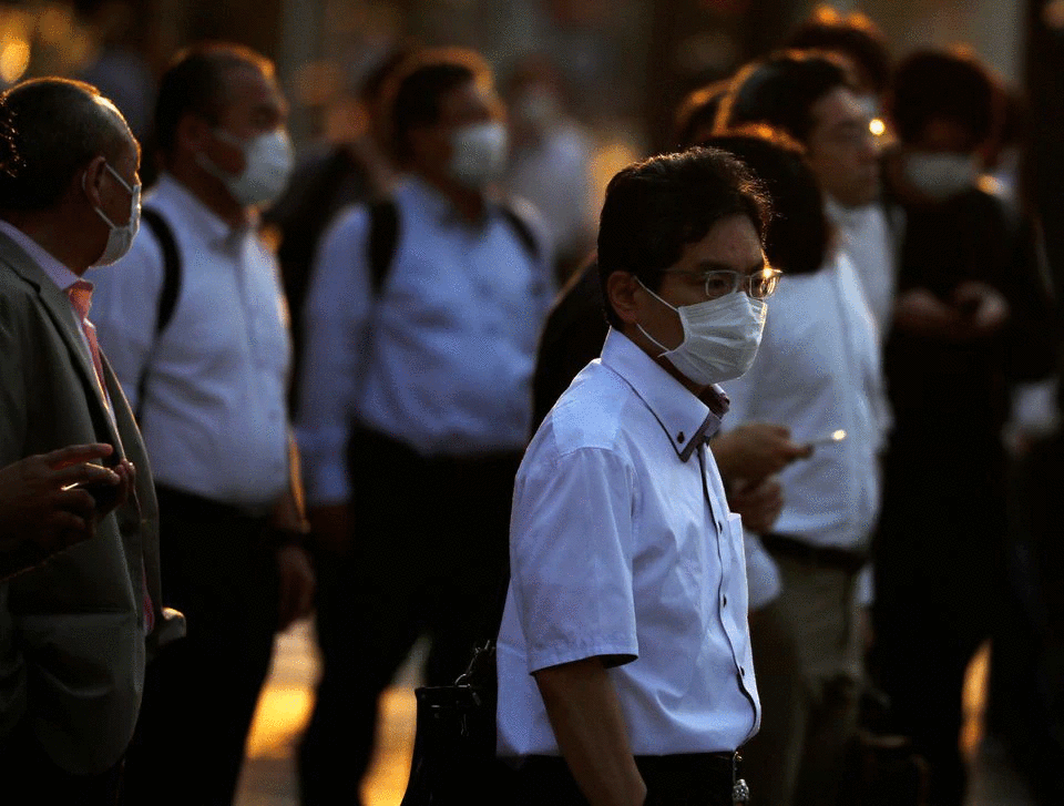 Office workers wearing protective face masks walk to head home at sunset amid the coronavirus disease (COVID-19) outbreak, in Tokyo, Japan June 9, 2020. Photo: Reuters