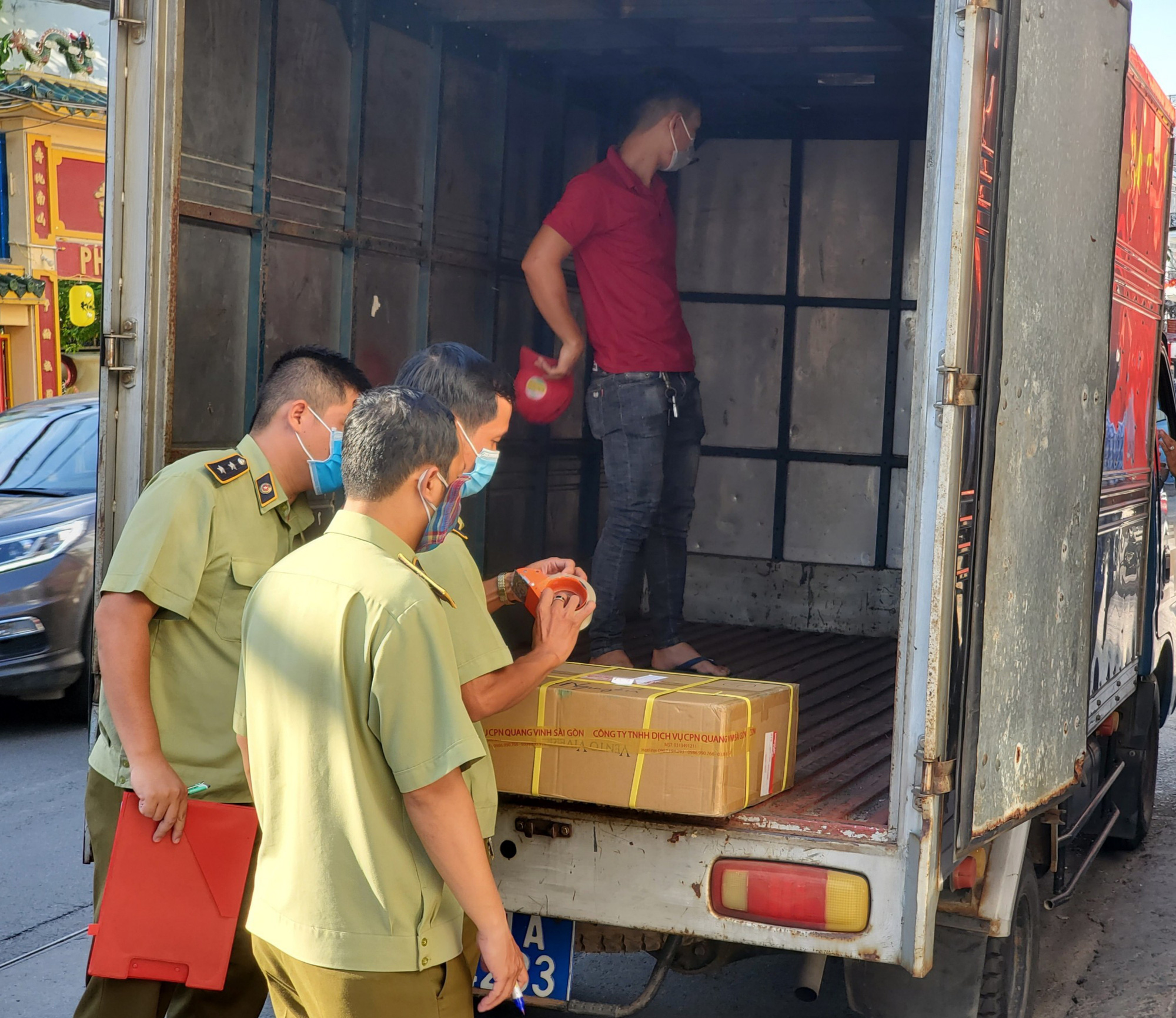 Market surveillance officers seal a package of allegedly-smuggled cosmetics on a truck in Phu Nhuan District, Ho Chi Minh City, May 20, 2021. Photo: N. Tri / Tuoi Tre