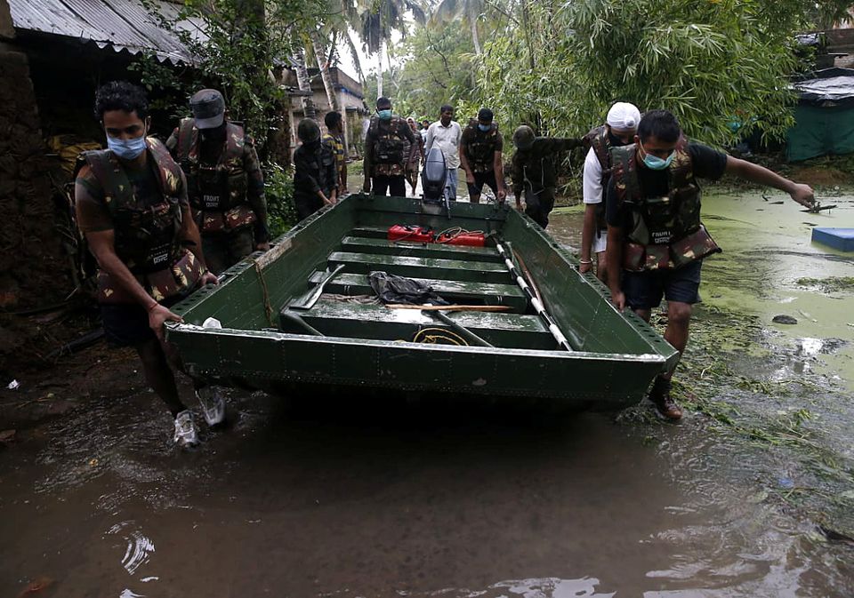 Army soldiers carry a boat to evacuate people from a flooded area as Cyclone Yaas makes landfall at Ramnagar in Purba Medinipur district in the eastern state of West Bengal, India, May 26, 2021. Photo: Reuters