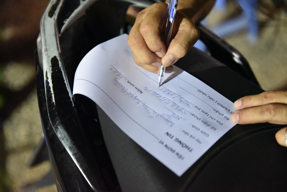 A local resident fills out a medical declaration form in Ward 15, Go Vap District, Ho Chi Minh City, May 28, 2021. Photo: Ngoc Phuong / Tuoi Tre