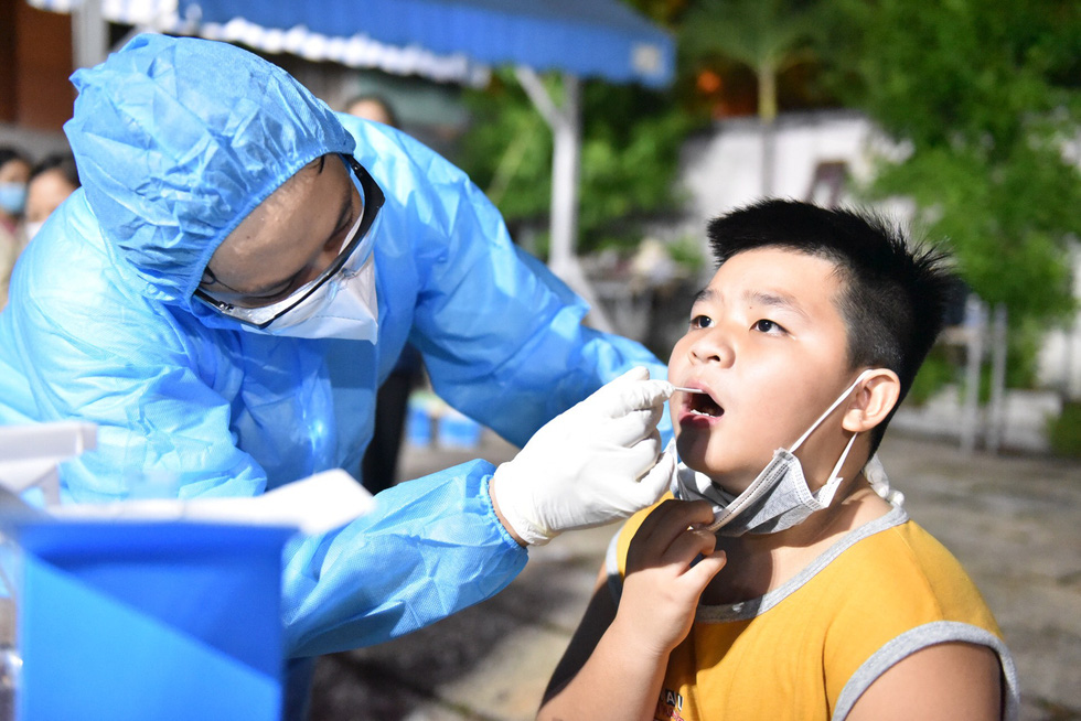 A health worker collects samples from a boy for COVID-19 testing in Ward 15, Go Vap District, Ho Chi Minh City, May 28, 2021. Photo: Ngoc Phuong / Tuoi Tre