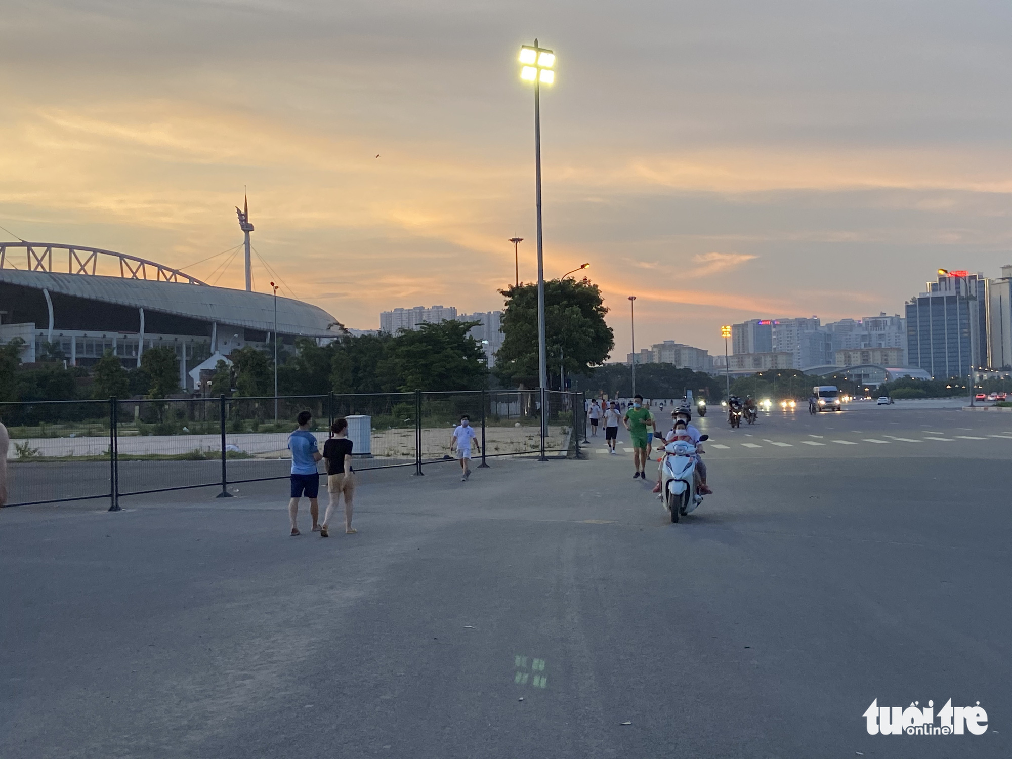 People walk on the sidewalk in front of the My Dinh National Stadium in Nam Tu Liem District, Hanoi, May 30, 2021. Photo: Q.T. / Tuoi Tre