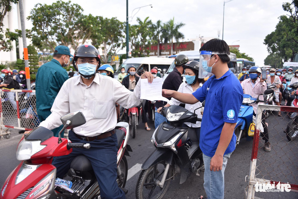 A commuter shows a ‘travel pass’ to be allowed to pass a COVID-19 checkpoint in Go Vap District, Ho Chi Minh City, June 1, 2021. Photo: Ngoc Phuong / Tuoi Tre