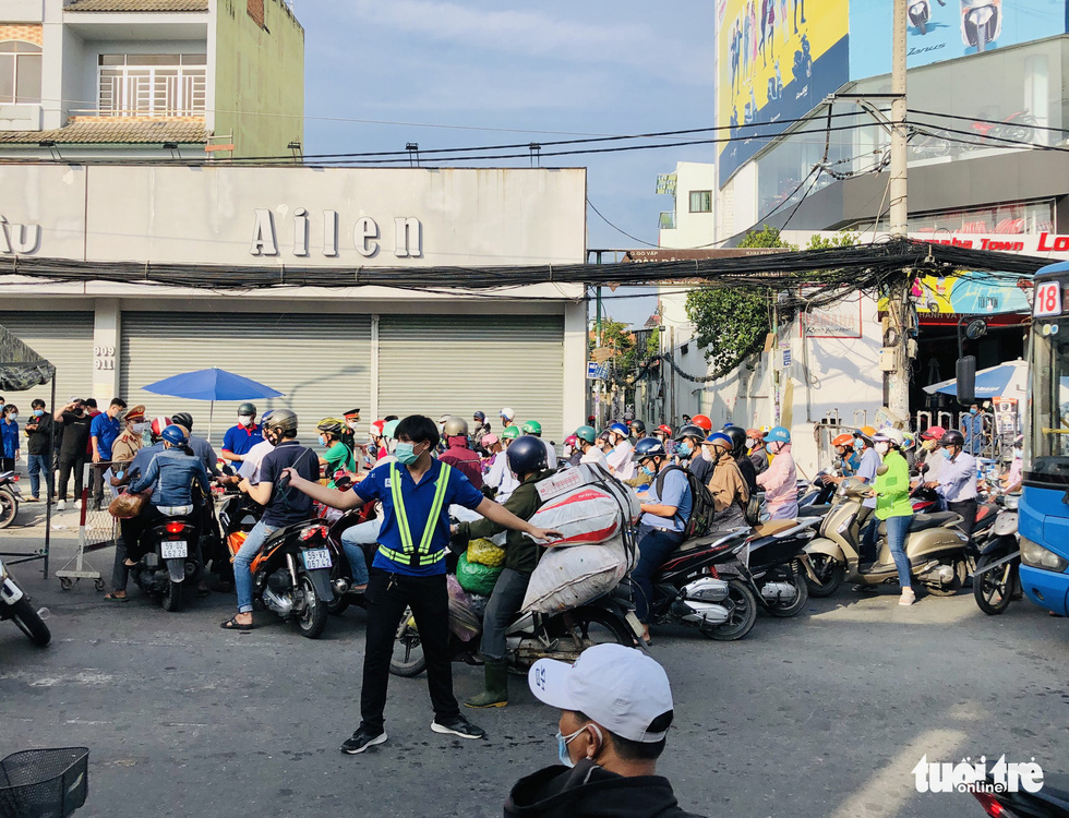 A volunteer handles traffic congestion at a COVID-19 checkpoint on Quang Trung Street in Go Vap District, Ho Chi Minh City, June 1, 2021. Photo: Chau Tuan / Tuoi Tre