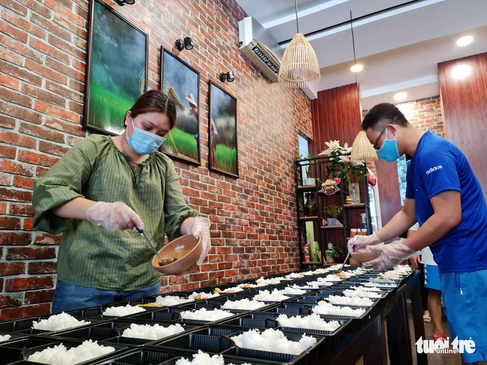 Yen Anh and Pham Minh Hien carefully prepare each donated meal. Photo: Cong Trieu / Tuoi Tre