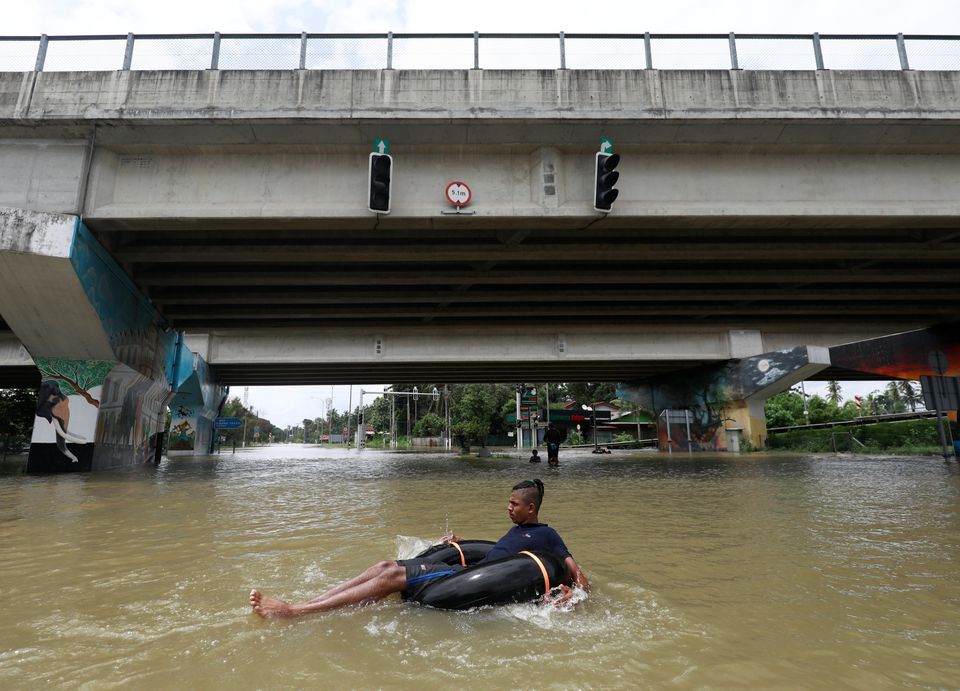 A man floats on a tube down a flooded road during a COVID-19 curfew in Kaduwela, a suburb town of Colombo, Sri Lanka June 6, 2021. Photo: Reuters