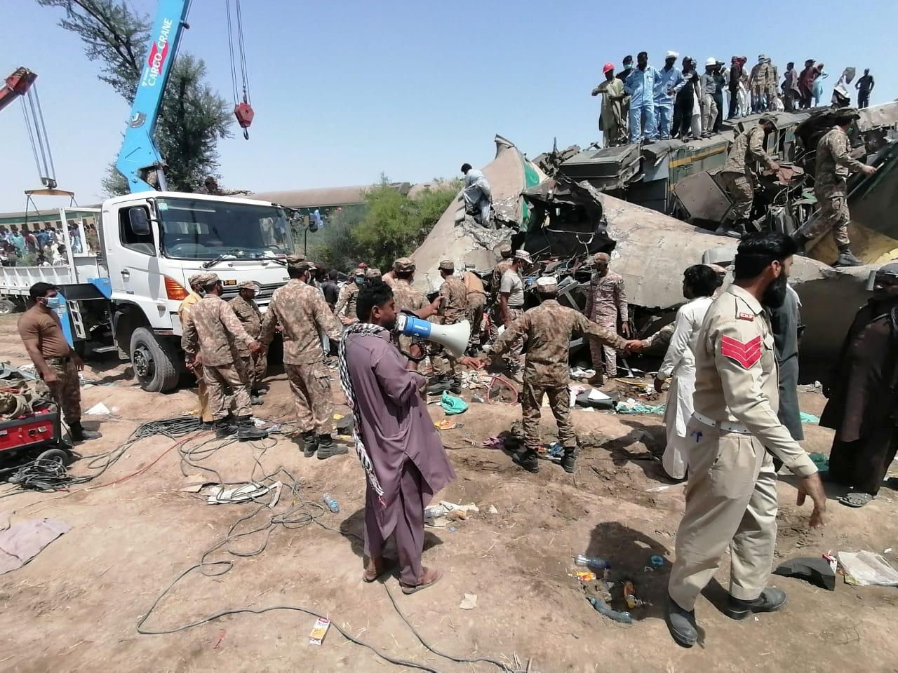 Paramilitary soldiers and rescue workers gather at the site following a collision between two trains in Ghotki, Pakistan June 7, 2021. Photo: Inter-Services Public Relations (ISPR)/ Handout via Reuters
