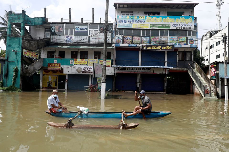 Men float along a flooded road during a COVID-19 curfew in Biyagama, near Colombo, Sri Lanka June 6, 2021. Photo: Reuters