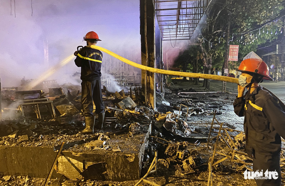 Firefighters are seen extinguishing the blaze at the tea house. Photo: Doan Hoa / Tuoi  Tre