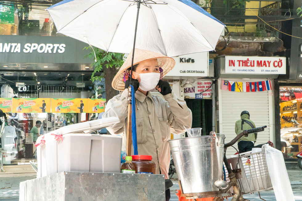 Vu Thi Phuong parks her bicycle on the street to sell “tao pho” in Hanoi, June 20, 2021. Photo: Pham Tuan / Tuoi Tre