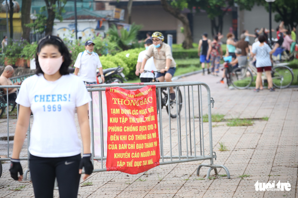 A sign reminding people of COVID-19 safety measures remains in place at a garden near Truc Bach Lake in Hanoi, June 26, 2021. Photo: Ha Quan / Tuoi Tre