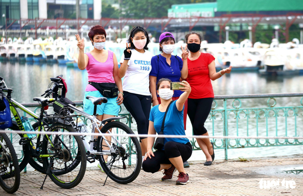 Women take a group photo after cycling around the West Lake in Hanoi, June 26, 2021. Photo: Ha Quan / Tuoi Tre