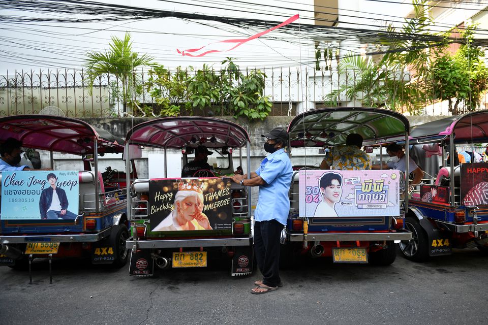 Tuk-tuk drivers, with their vehicles decorated with banners of Thai and Korean stars, wait for customers in Bangkok, Thailand May 12, 2021. Picture taken May 12, 2021. Photo: Reuters