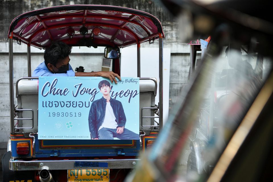 A tuk-tuk driver, with his vehicle decorated with a banner of a Korean star, waits for customers in Bangkok, Thailand May 12, 2021. Picture taken May 12, 2021. Photo: Reuters