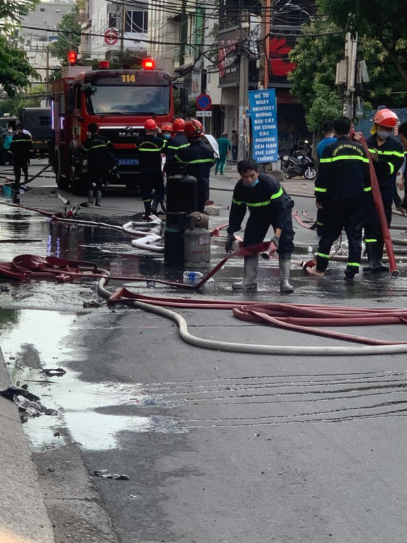 Fire policemen use water hoses to control the fire in Tan Binh District, Ho Chi Minh City, June 30, 2021. Photo: M.H. / Tuoi Tre