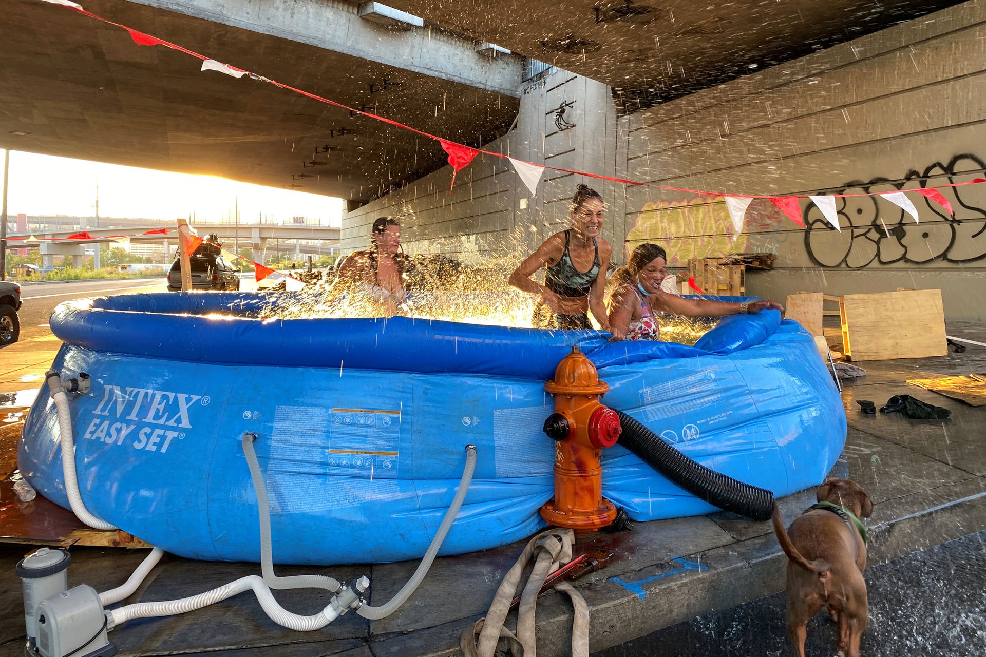 Cindy Bedinger, 48, cools off in a swimming pool hooked to a fire hydrant under a freeway underpass during a heatwave in Portland, Oregon, U.S., June 29, 2021. Photo: Reuters