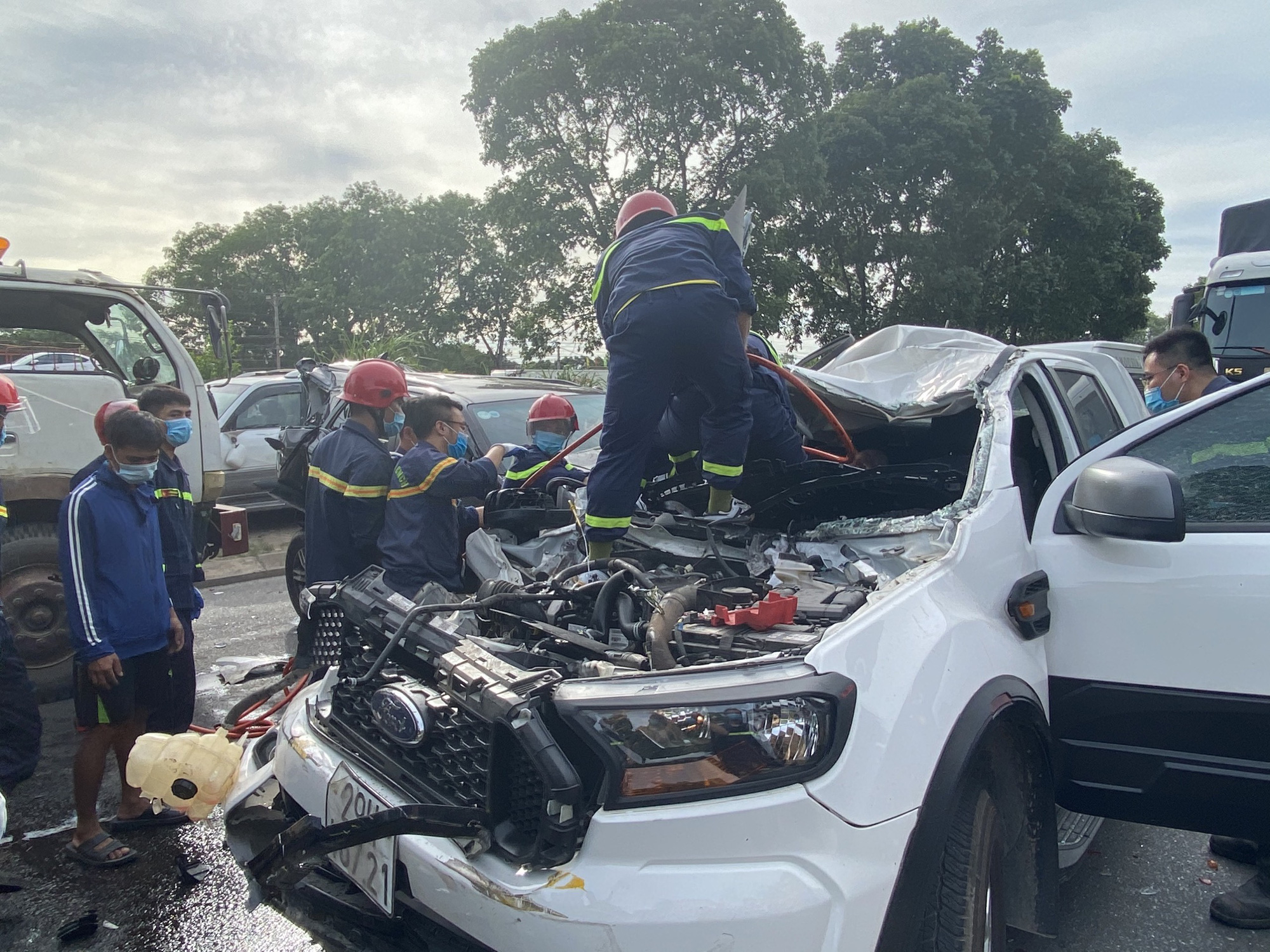 This photo supplied by police in Thanh Hoa Province shows rescuers taking out a victim stuck inside a pickup truck at the scene of a serial traffic accident on National Highway 1A, Bim Son Town, July 2, 2021.