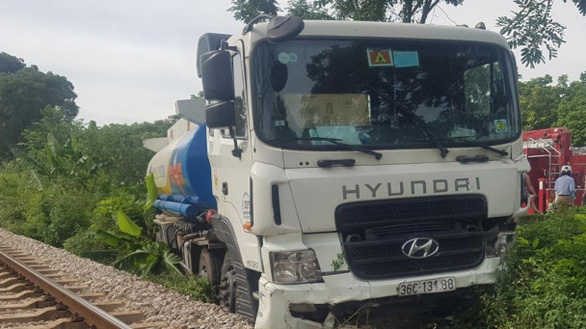 This photo supplied by police in Thanh Hoa Province shows an oil tanker stop next to a railway track near the scene of a serial traffic accident on National Highway 1A, Bim Son Town, July 2, 2021.