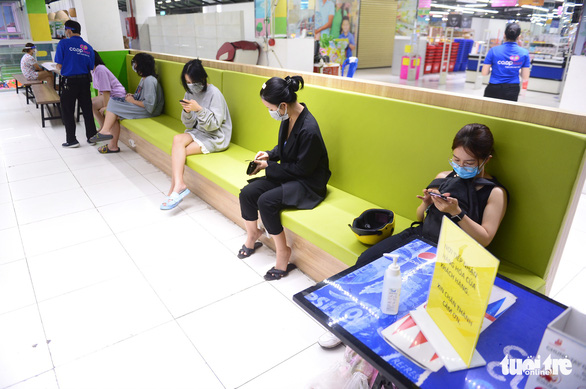 Customers in a Co.opmart supermarket in Ho Chi Minh City keep a safe distance from each other while waiting for their grocery packages. Photo: Quang Dinh / Tuoi Tre