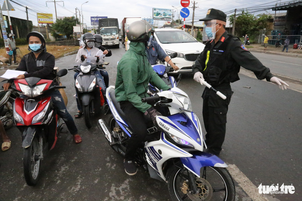 An officer turns a commuter away for not having a coronavirus-negative certificate on National Highway 1, July 8, 2021. Photo: Le Phan / Tuoi Tre