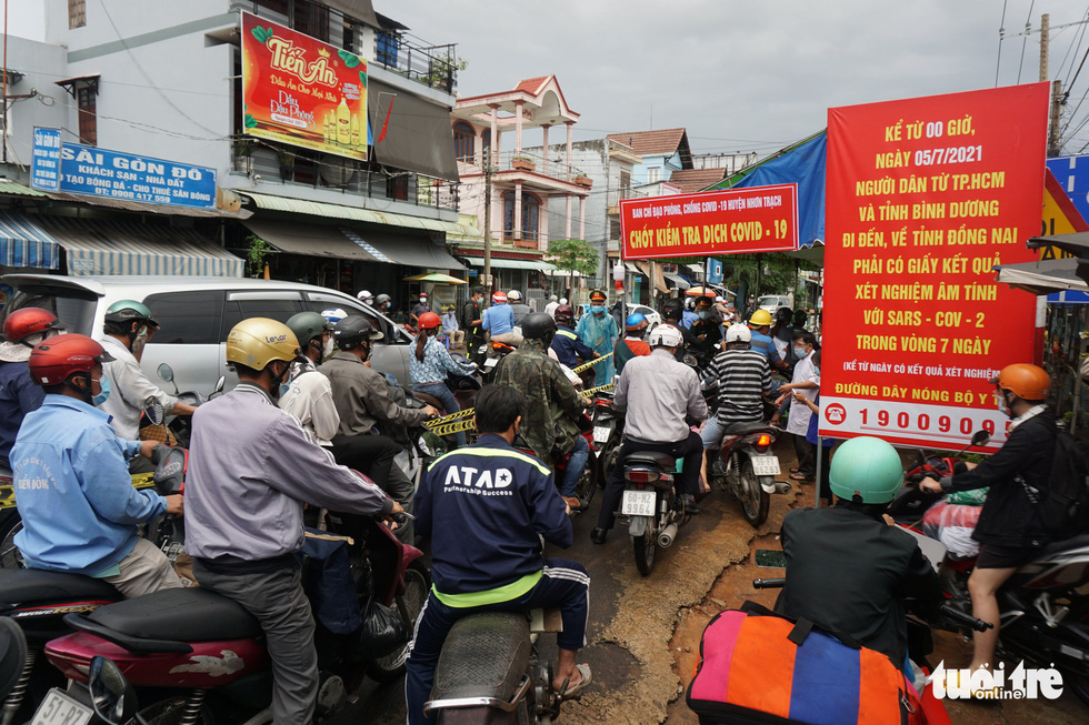 Commuters wait to have their coronavirus-negative certificates checked at the entrance to Cat Lai Ferry in Dong Nai Province, Vietnam, July 8, 2021. Photo: Duc Phu / Tuoi Tre