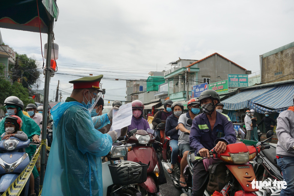 Commuters wait to have their coronavirus-negative certificates checked at the entrance to Cat Lai Ferry in Dong Nai Province, Vietnam, July 8, 2021. Photo: Duc Phu / Tuoi Tre