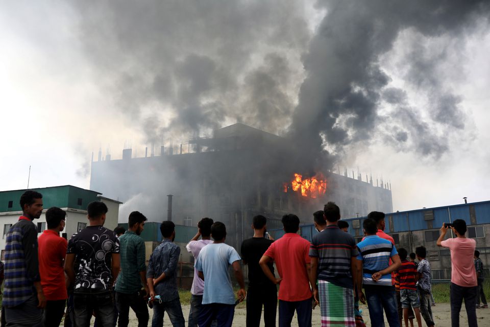 People look on as flames rise after a fire broke out at a Hashem Foods Ltd factory in Rupganj, Narayanganj district, on the outskirts of Dhaka, Bangladesh, July 9, 2021. Photo: Reuters