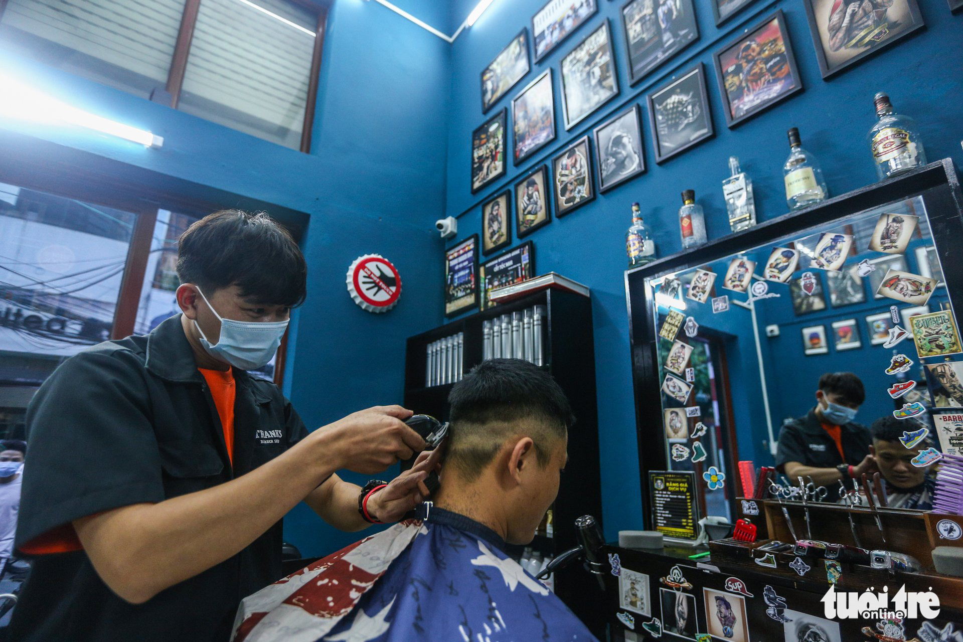 Giap Van Duy gives his customer a haircut at his barbershop in Thanh Xuan District, Hanoi, July 12, 2021. Photo: Ha Quan / Tuoi Tre