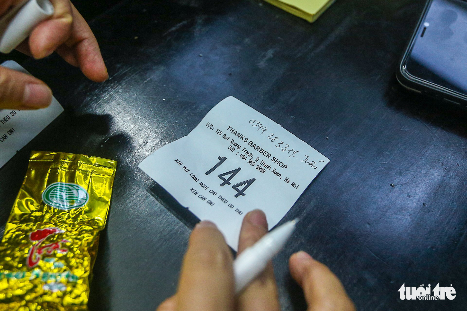 A queue number ticket at a barbershop on Bui Xuong Trach Street, Thanh Xuan District, Hanoi, July 12, 2021. Photo: Ha Quan / Tuoi Tre