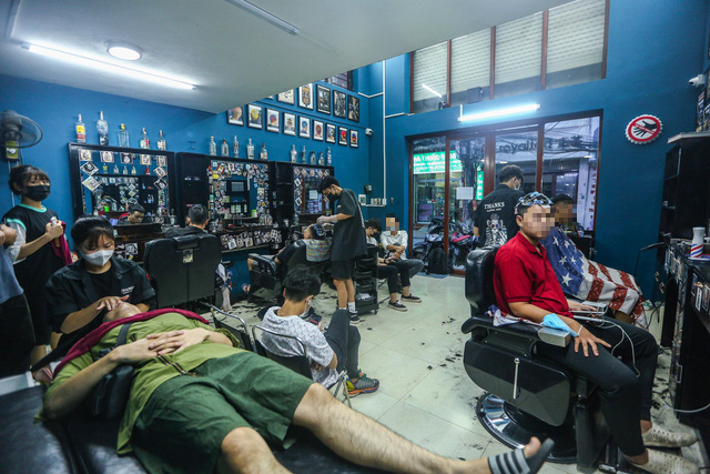 Customers wait to get haircuts at a barbershop on Bui Xuong Trach Street, Thanh Xuan District, Hanoi, July 12, 2021. Photo: Ha Quan / Tuoi Tre
