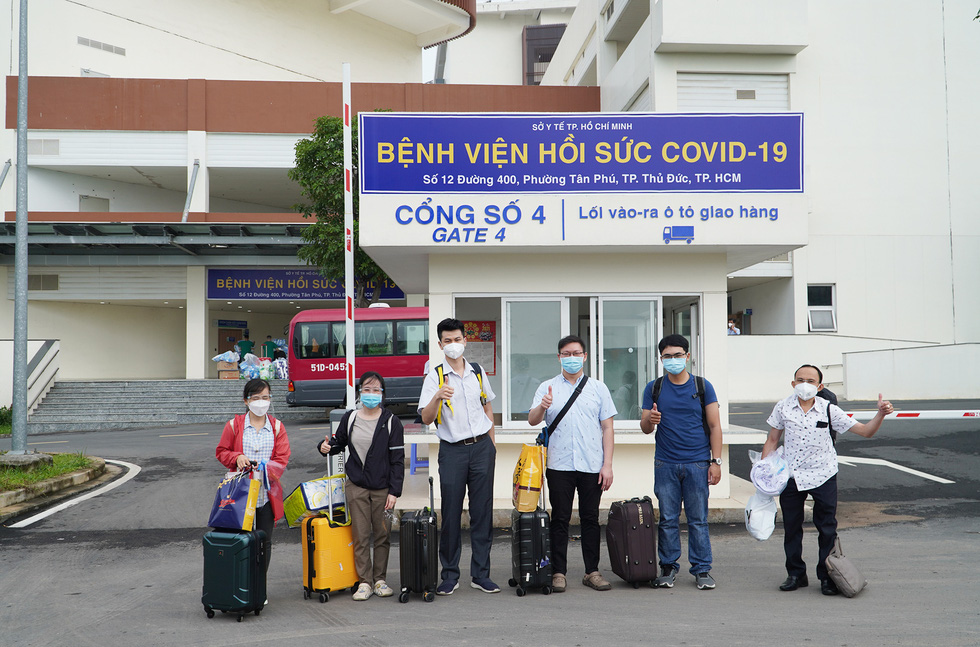 Health workers from Cho Ray Hospital pose for a photo in front of a gate of the Emergency Resuscitation Hospital in Ho Chi Minh City. Photo: An My / Tuoi Tre