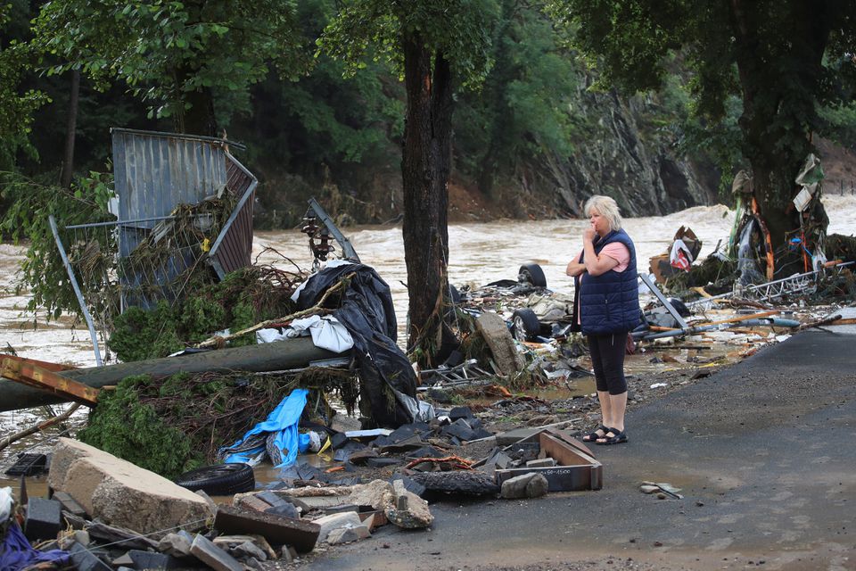 A woman looks at debris brought by the flood next to the Ahr river, following heavy rainfalls in Schuld, Germany, July 15, 2021. Photo: Reuters
