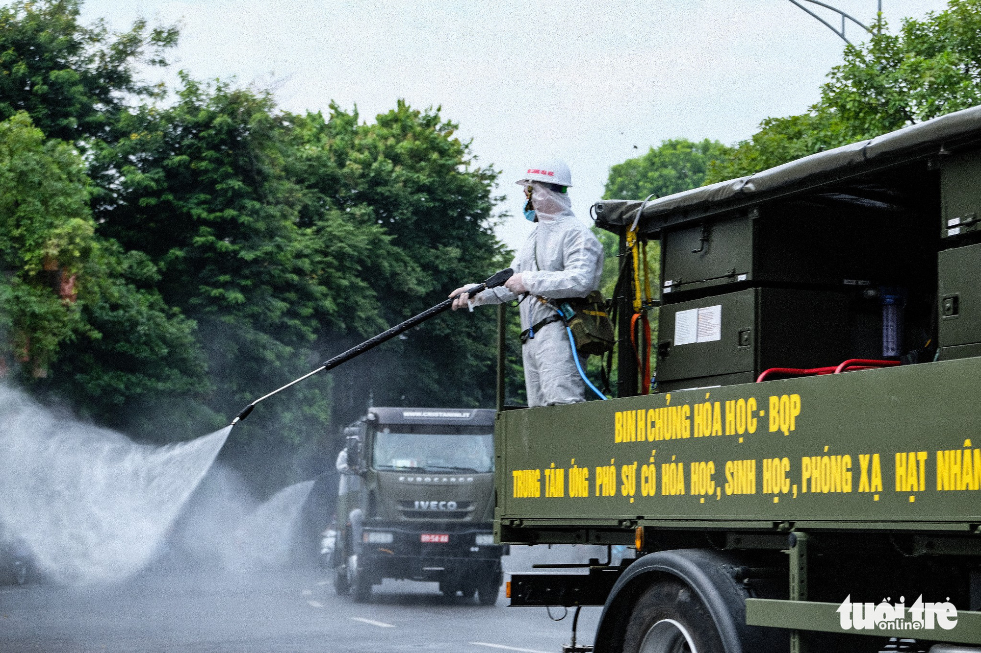 A soldier sprays chemical from atop a specialized vehicle to disinfect a street in Hoan Kiem District, Hanoi, July 26, 2021. Photo: Nam Tran / Tuoi Tre