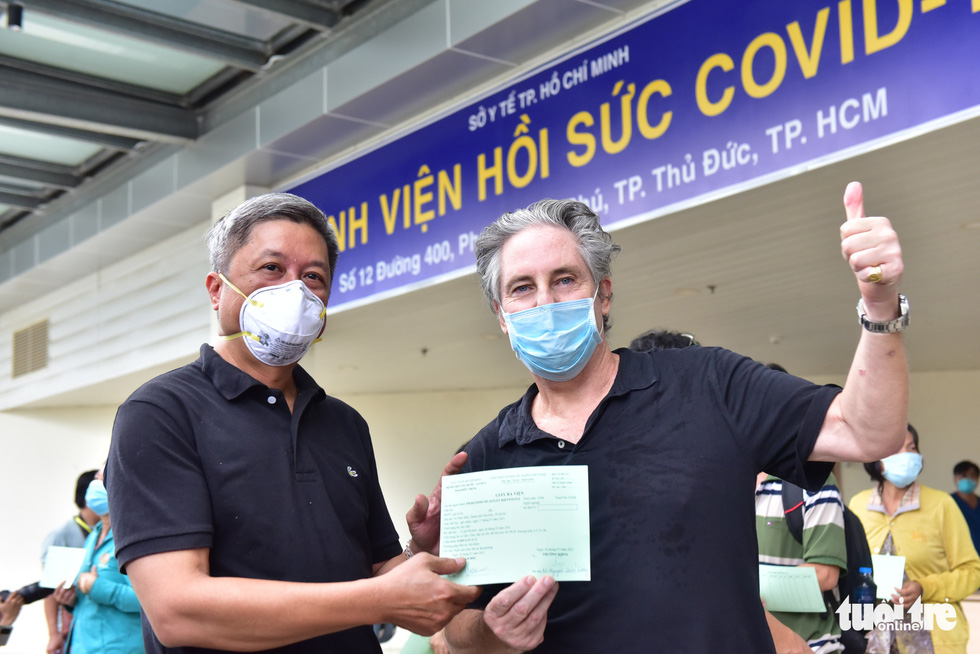 Nguyen Truong Son, Deputy Minister of Health, hands over the certificate of discharge to a British patient, July 26, 2021. Photo: Duyen Phan / Tuoi Tre