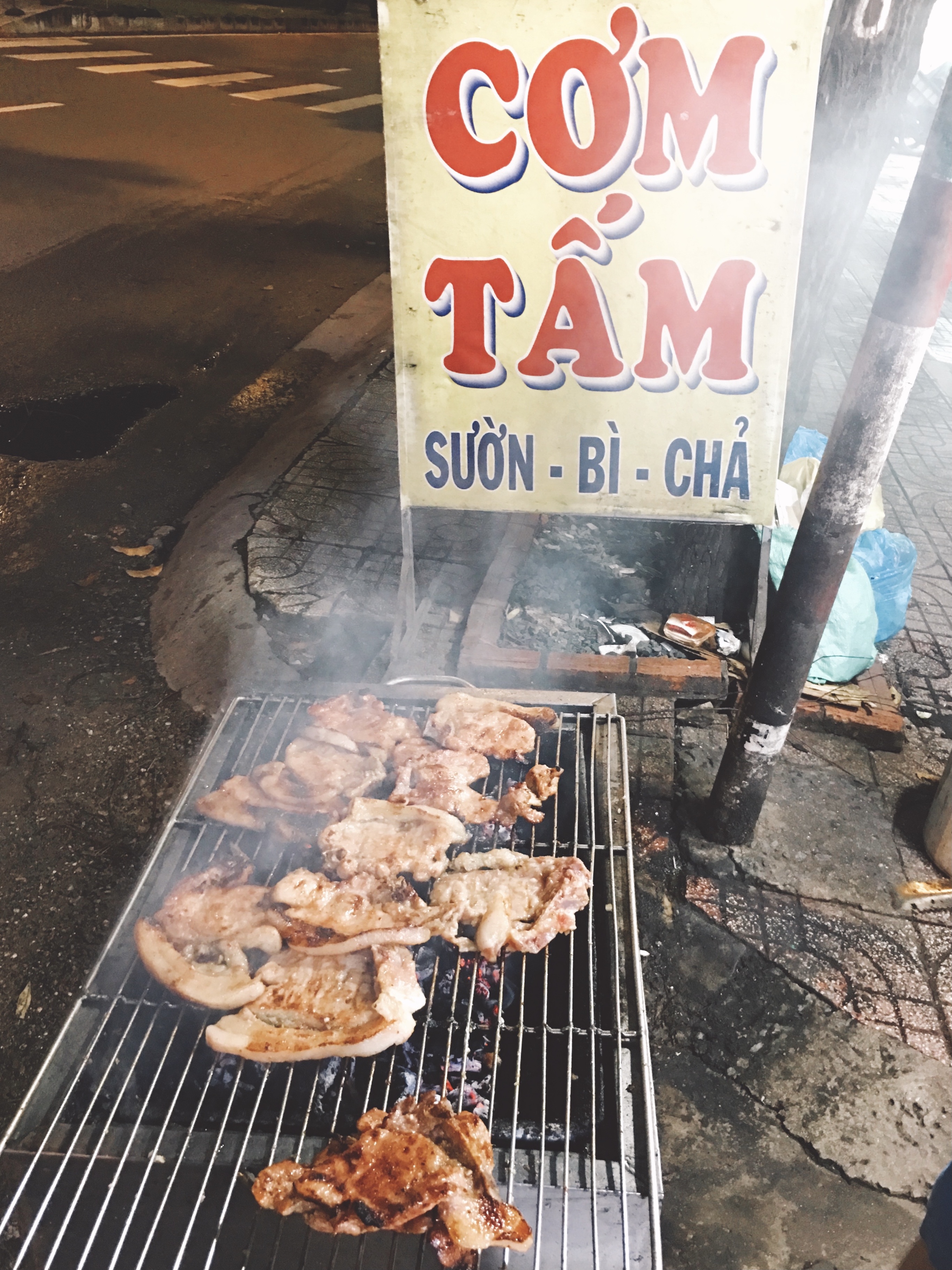 Grilled ribs and a sign reads 'Com tam' on the sidewalk is how you know you are in Saigon. Photo: Dong Nguyen / Tuoi Tre News