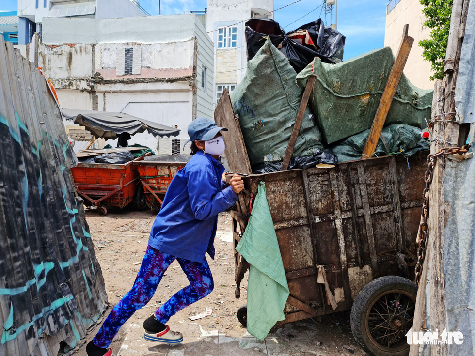 Truong Thuy Van, 43, a sanitation worker for District 3 of Ho Chi Minh City, pushes a trash cart to the depot. Photo: Cong Trieu / Tuoi Tre