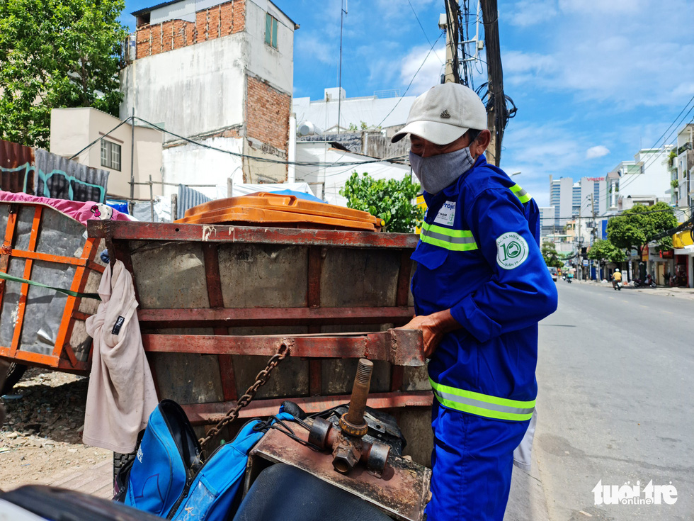 Le Van Phuc, 51, a sanitation worker in Ho Chi Minh City, pushes a trash cart. Photo: Cong Trieu / Tuoi Tre
