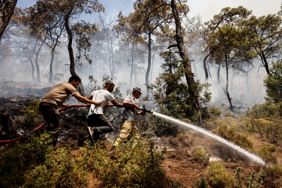 Firefighters and volunteers extinguish a wildfire near Marmaris, Turkey, August 1, 2021. Photo: Reuters