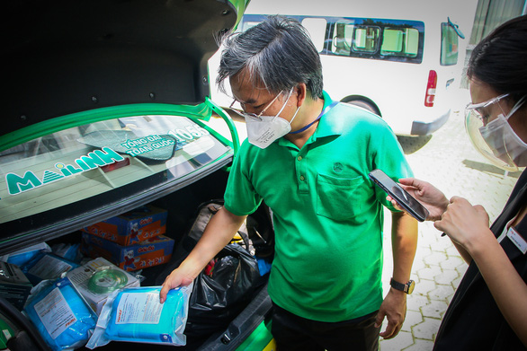A Mai Linh Taxi driver prepares PPE items on his vehicle, August 4, 2021. Photo: Chau Tuan / Tuoi Tre
